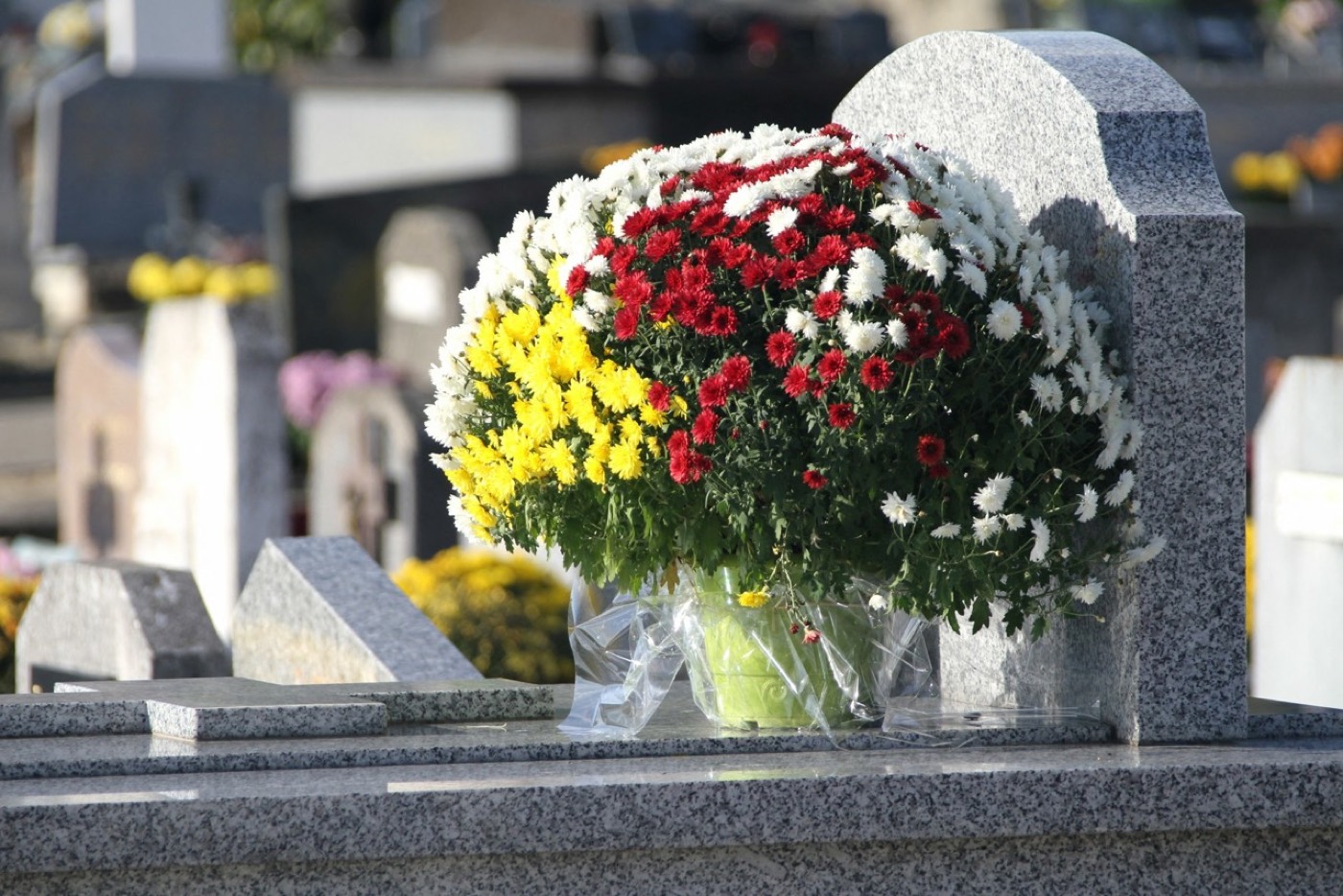 Fleurs et roses sur une sépulture en granit